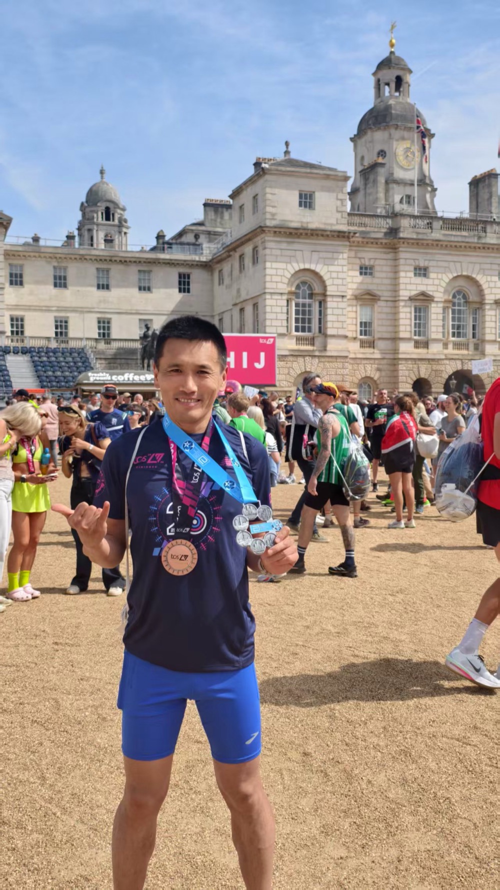 Runner with London Marathon finisher medals after a 2:55:43 finish
